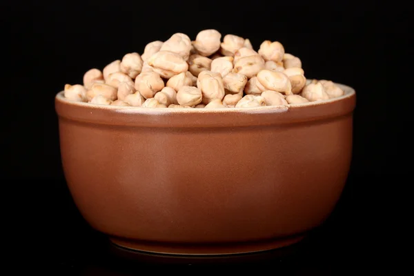 White chickpeas in brown bowl isolated on black — Stock Photo, Image