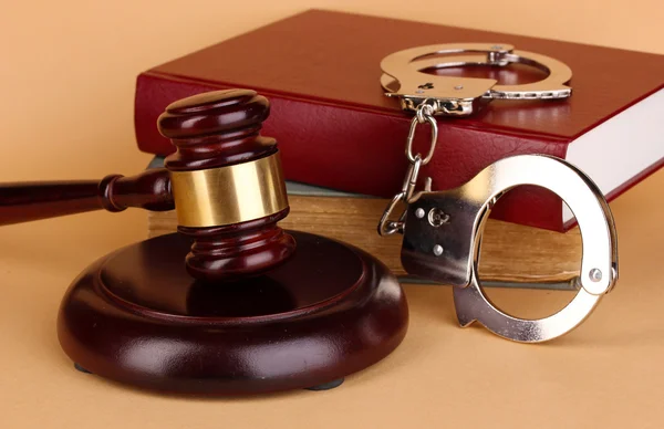 Gavel, handcuffs and book on law on beige background — Stock Photo, Image