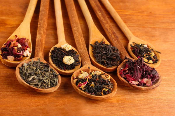 Asortyment suchej herbaty w łyżki, na tle drewniane — Zdjęcie stockowe