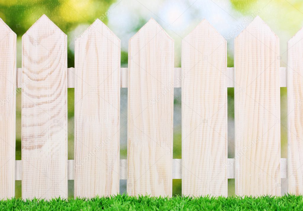 wooden fence and green grass on bright background