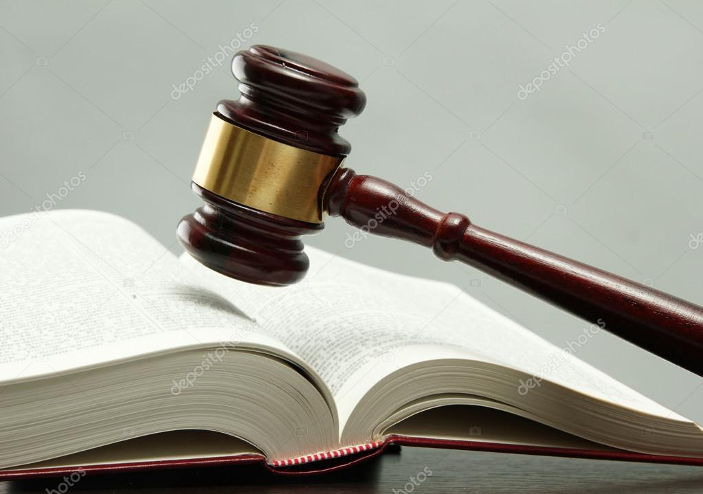 wooden gavel and book on wooden table, on grey background