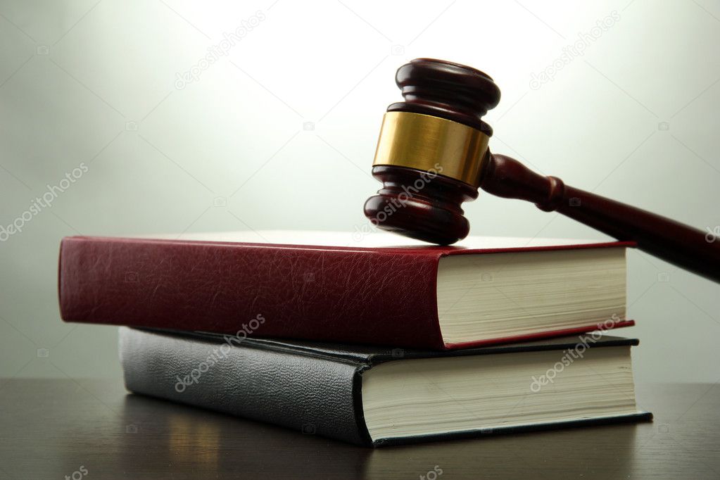 wooden gavel and books on wooden table,on grey background