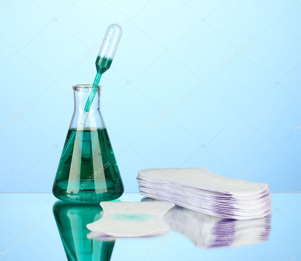 Testing sanitary pads for absorbency, on blue background closeup Stock