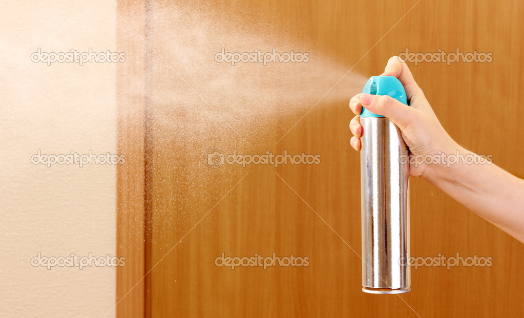 Sprayed air freshener in hand on room background Stock Photo by ©belchonock 13745068