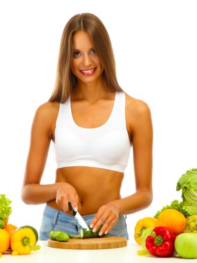 güzel bir genç kadın kesme sebze, üzerinde beyaz izole