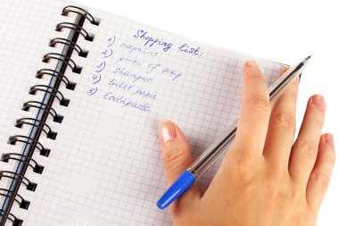 Kadının elinde alışveriş listesi olan bir defter var.