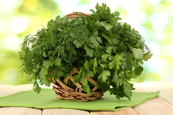 Houten mandje met peterselie en Dille op houten tafel op natuurlijke achtergrond — Stockfoto