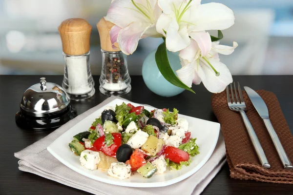 Fresh greek salad on white plate on table on restaurant background — Stock Photo, Image