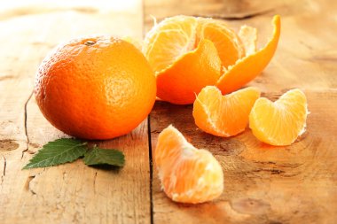 Ripe tasty tangerines on wooden background clipart