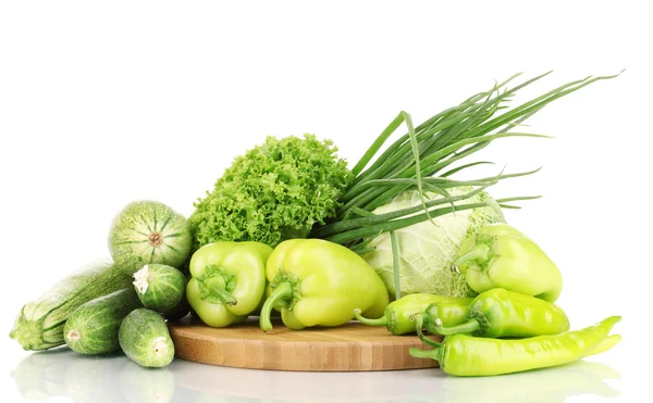 Legumes verdes frescos em tábua de corte isolado em branco — Fotografia de Stock