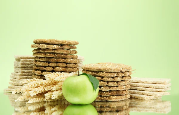 Tasty crispbread apple and ears, on green background — Stock Photo, Image