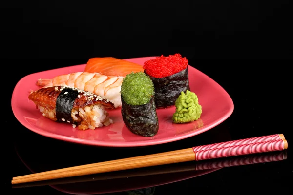 Délicieux sushi servi sur plaque rouge isolé sur noir — Photo