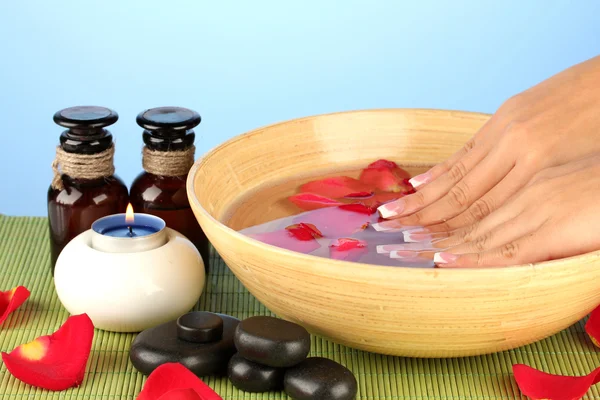 Tratamientos de spa para manos femeninas, sobre fondo azul — Foto de Stock