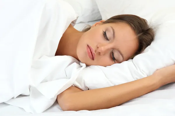 Молодая красивая женщина спит в постели — стоковое фото