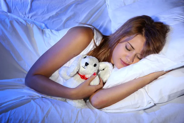 Όμορφη κοπέλα με το παιχνίδι κουνελιών που κοιμούνται στο κρεβάτι στην κρεβατοκάμαρα — Φωτογραφία Αρχείου