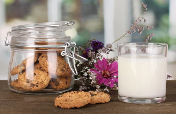 Glas Milch mit Keksen auf Holztisch vor Fenster Hintergrund Nahaufnahme — Stockfoto
