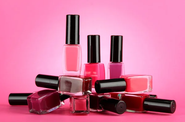 Grupo de esmaltes de uñas brillantes, sobre fondo rosa —  Fotos de Stock