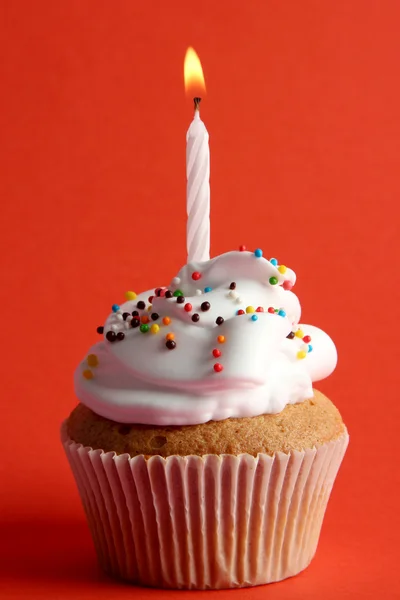 Tasty birthday cupcake with candle, on red background Stock Photo
