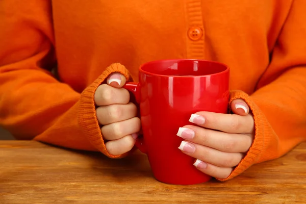 Mãos segurando caneca de bebida quente, close-up — Fotografia de Stock