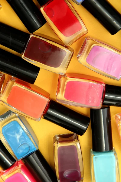 Group of bright nail polishes, on yellow background — Stock Photo, Image