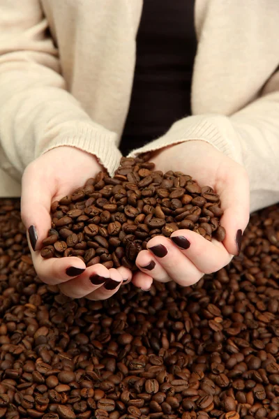 Mãos femininas com grãos de café, close-up — Fotografia de Stock
