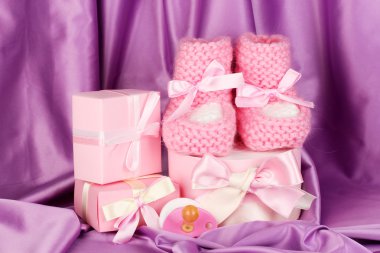 pembe bebek botları, emzik, ipek zemin üzerinde hediyeler