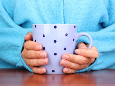 yakın çekim sıcak bir fincan tutan eller iç