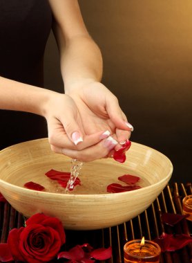 kadın eliyle su yaprakları kahverengi zemin üzerine ahşap kase