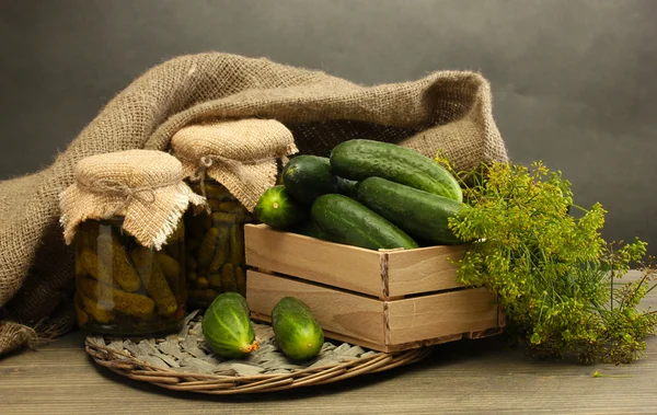 新鲜黄瓜在木盒、 泡菜和莳萝，灰色的背景上 — 图库照片