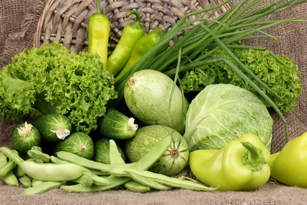 Verse groene groenten op rouwgewaad achtergrond — Stockfoto