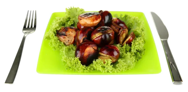 Roasted chestnuts with lettuce in the green plate with fork and knife isola — Stock Photo, Image