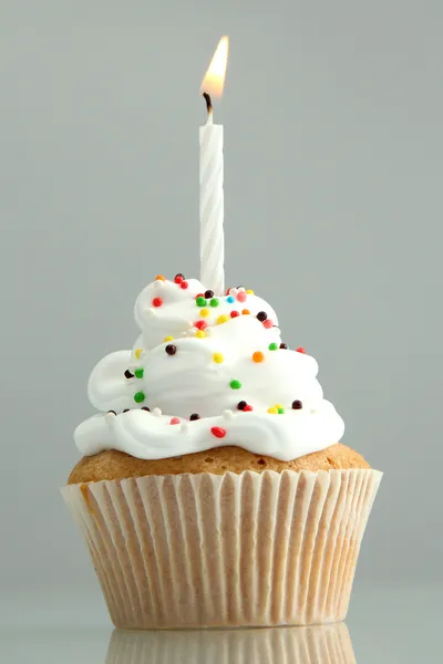 Tasty birthday cupcake with candle, on grey background — Stock Photo, Image