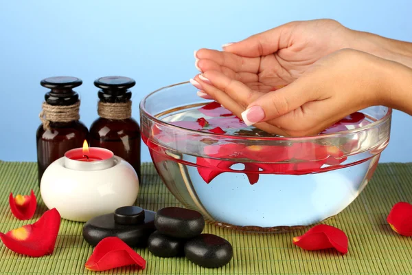 Tratamientos de spa para manos femeninas, sobre fondo azul — Foto de Stock