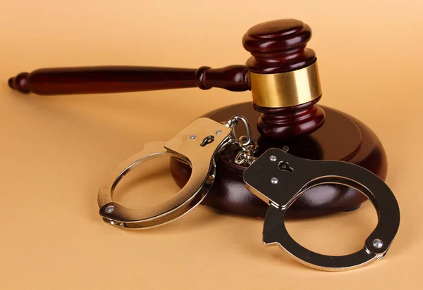 Gavel and handcuffs on beige background — Stock Photo, Image