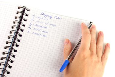 Kadının elinde alışveriş listesi olan bir defter var.