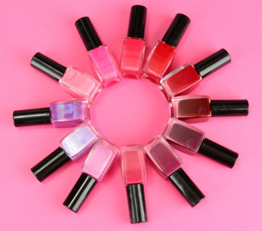 parlak tırnak cilaları, pembe bir arka plan üzerinde grup