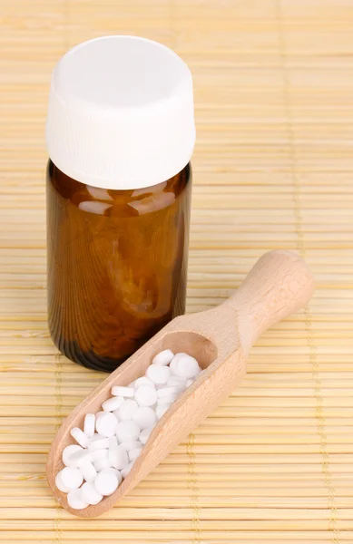 Medicine bottle with tablets on bamboo mat — Stock Photo, Image