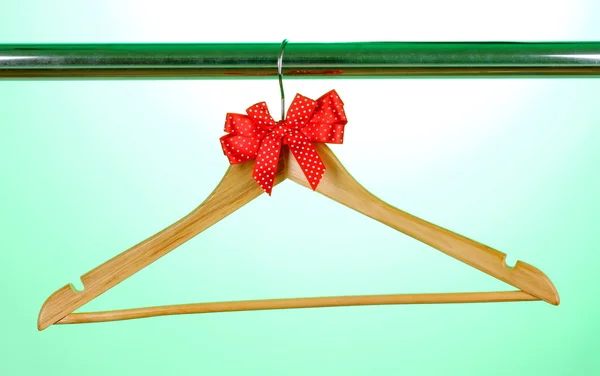 Hermoso arco rojo colgando en percha de madera sobre fondo verde — Foto de Stock