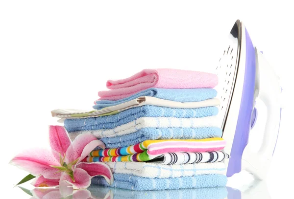 Pile of clothes with lily and electric iron, isolated on white — Stock Photo, Image