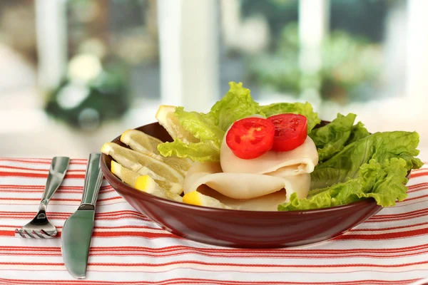 Gekookt inktvis met groenten op de plaat op tafellaken close-up — Stockfoto