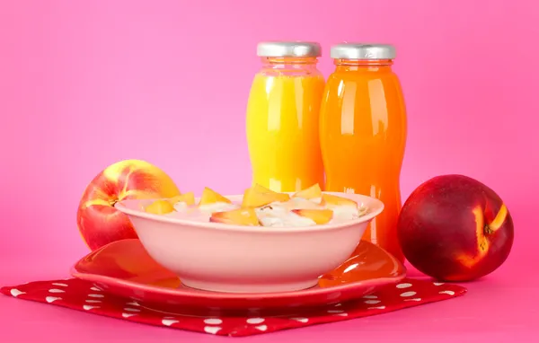 Tasty dieting food and bottles of juice, on pink background — Stock Photo, Image