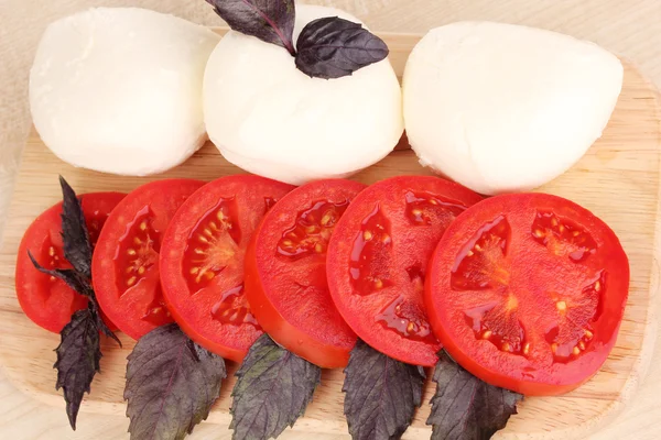 Savoureuse mozzarella aux tomates sur planche à découper close-up — Photo