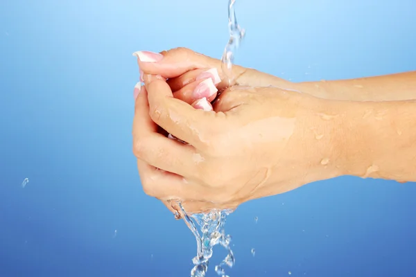 Mencuci tangan wanita pada latar belakang biru close-up — Stok Foto