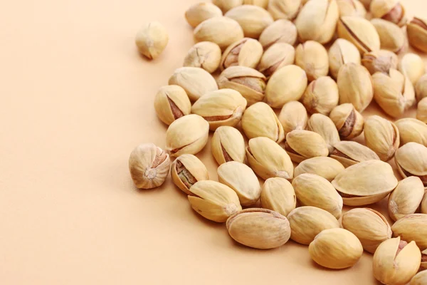 Tasty pistachio nuts, on beige background — Stock Photo, Image