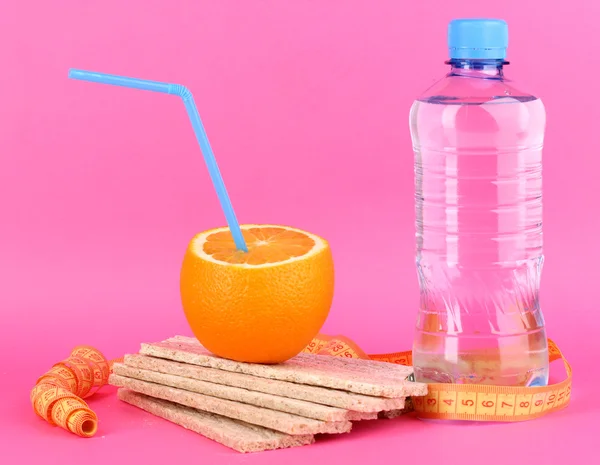 Ripe oranges, loafs and bottle of water as symbol of diet on pink backgroun — Stock Photo, Image