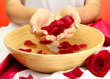 kadın eliyle su yaprakları kırmızı zemin üzerine ahşap kase