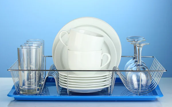 Clean dishes on stand on blue background — Stock Photo, Image