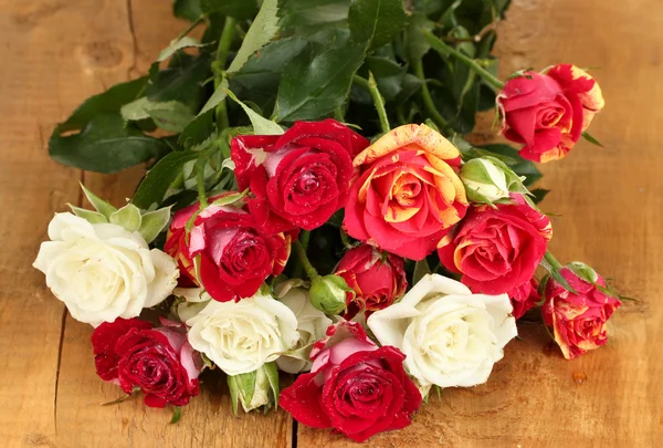 Strauß schöner Rosen auf Holzhintergrund in Nahaufnahme — Stockfoto