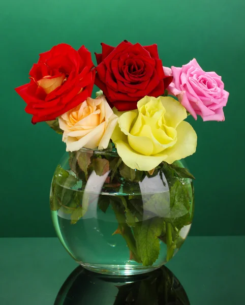 Yeşil zemin üzerine cam vazoda güzel güller — Stok fotoğraf