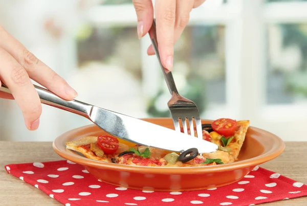 Mains de femme couper une tranche de pizza gros plan — Photo